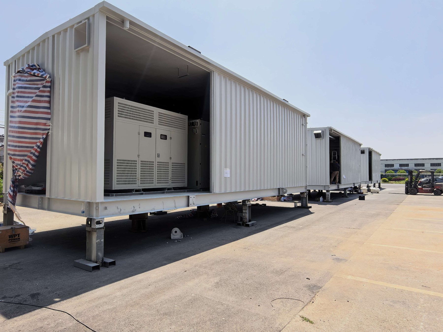 Containerized E-House modules staged in factory yard with installed equipment